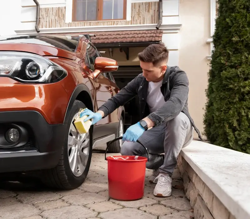 Lavage auto à domicile Villemagne-l'Argentière : professionnel intervenant sur un véhicule